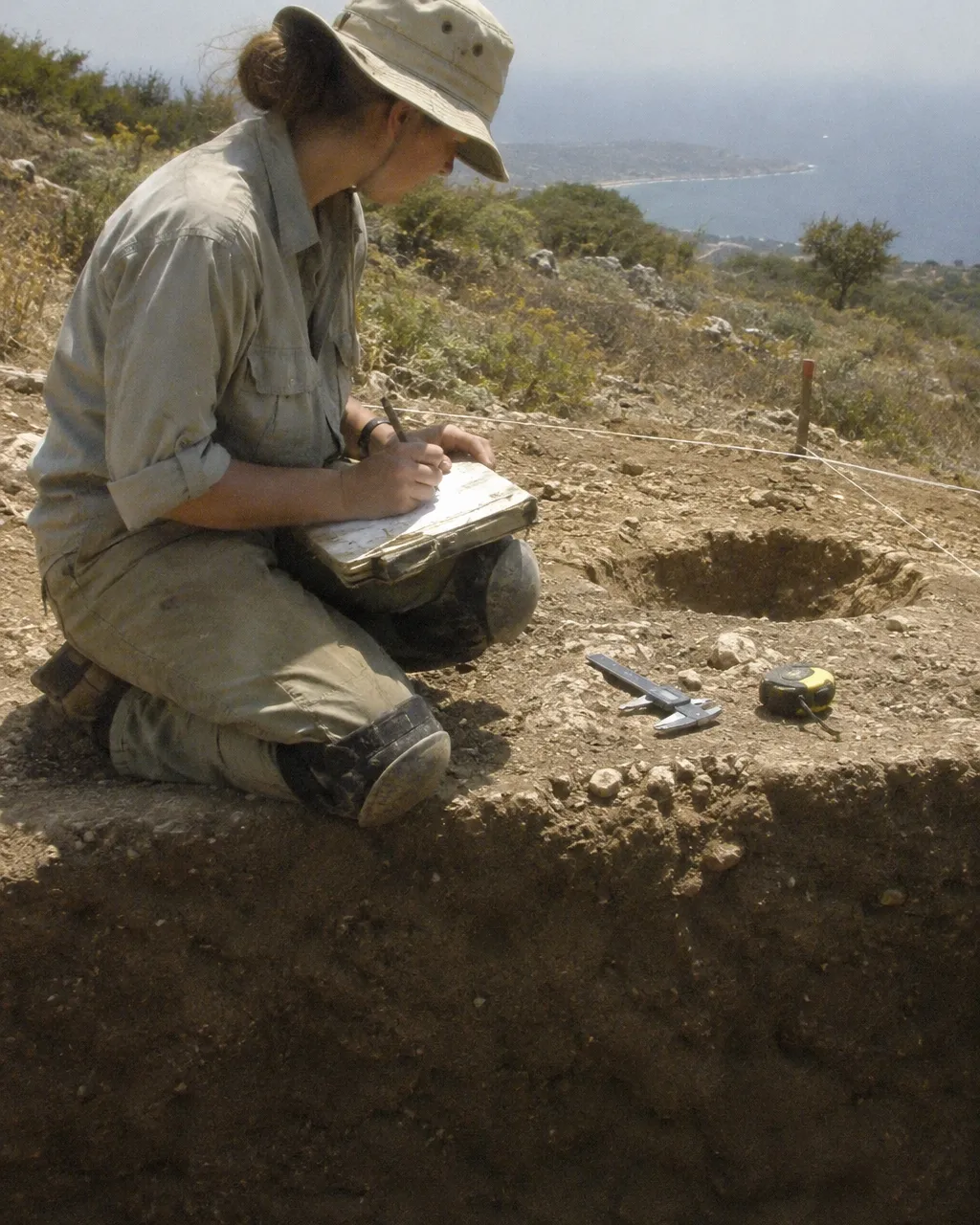 Un zooarqueólogo trabaja en una excavación neolítica en una ladera seca de caliza en Chipre